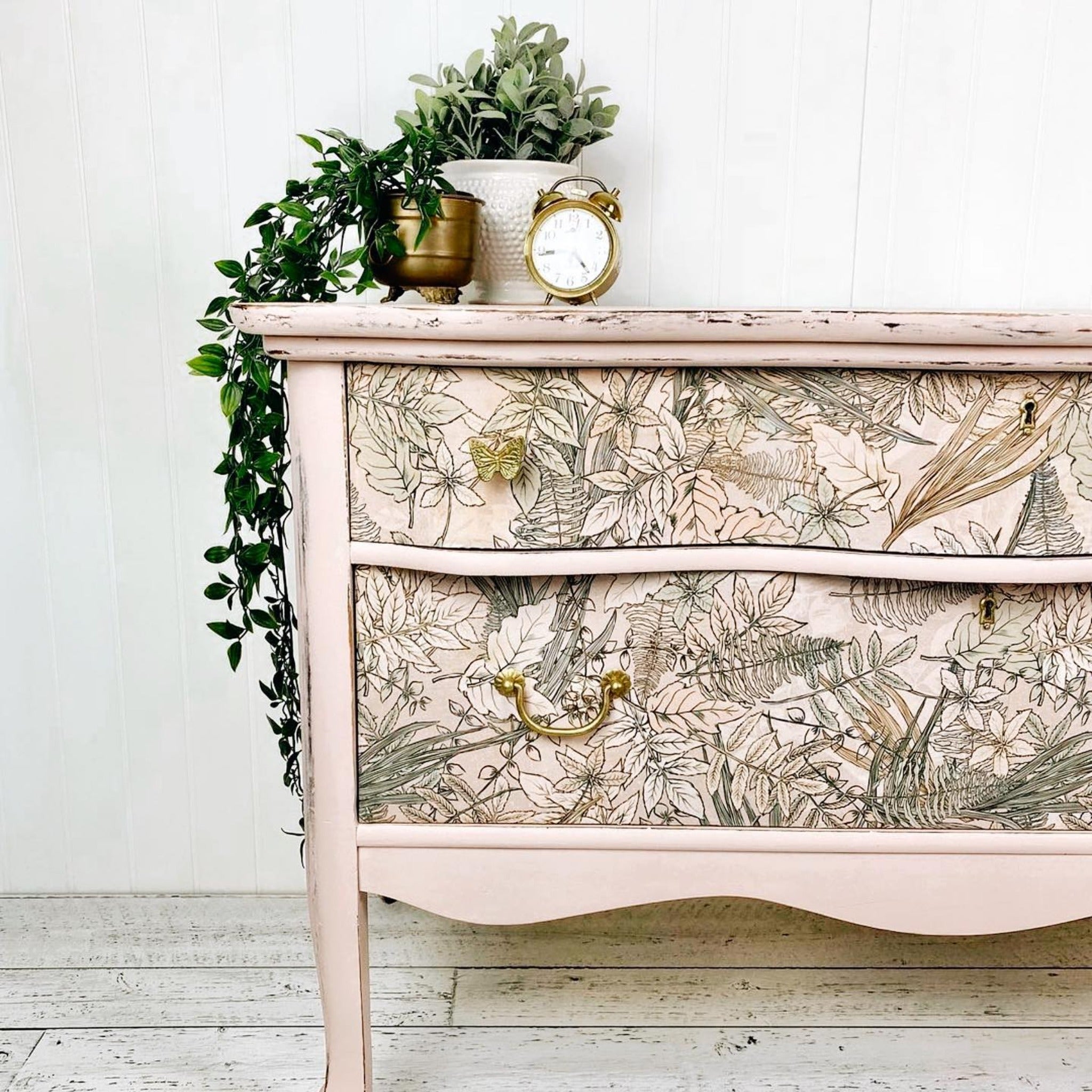 A vintage dresser is painted pale pink and features ReDesign with Prima's Tranquil Autumn tissue paper on its 2 drawers.