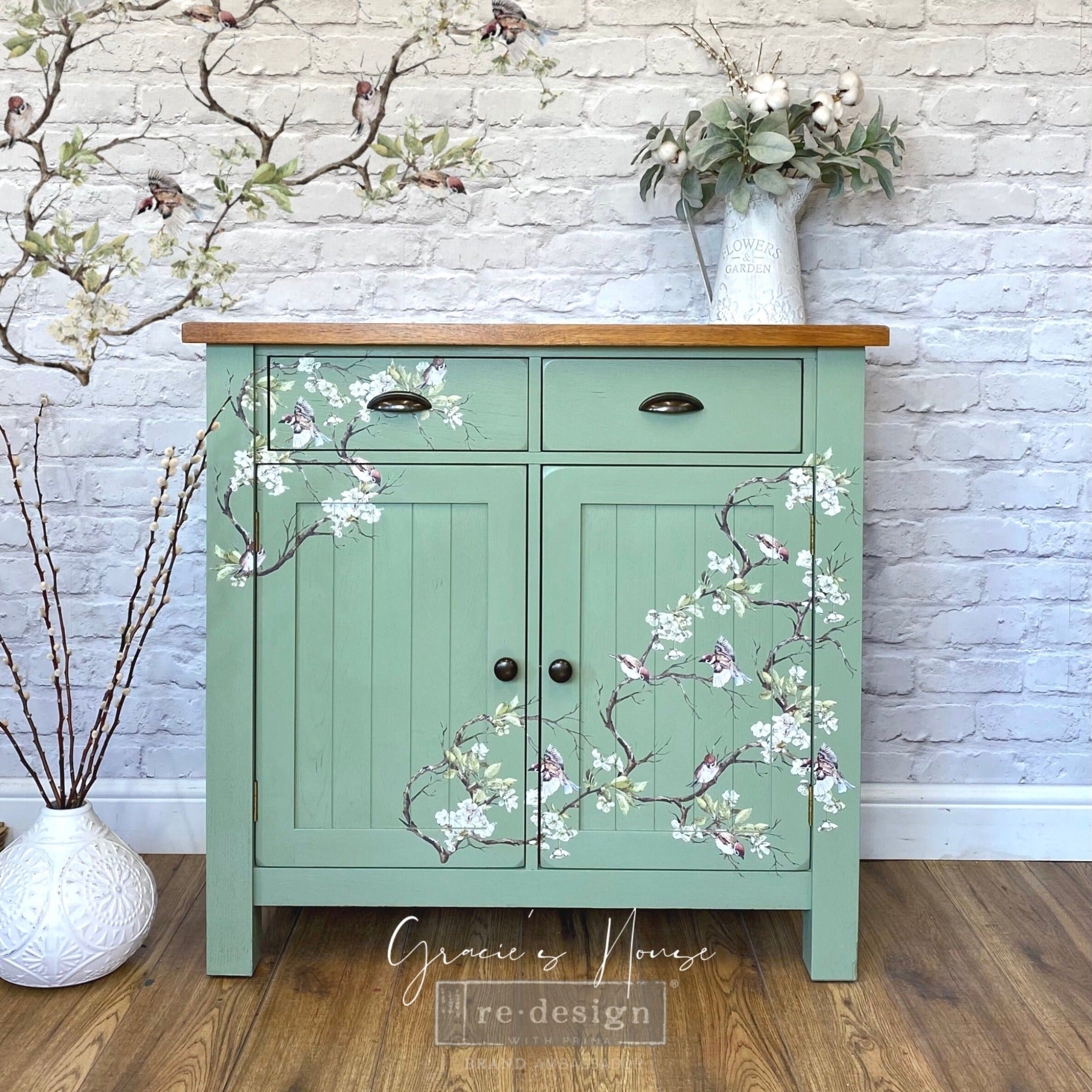A small buffet table refurbished by Gracie's House is painted mint green and features ReDesign with Prima's Blossom Flight transfer on it.