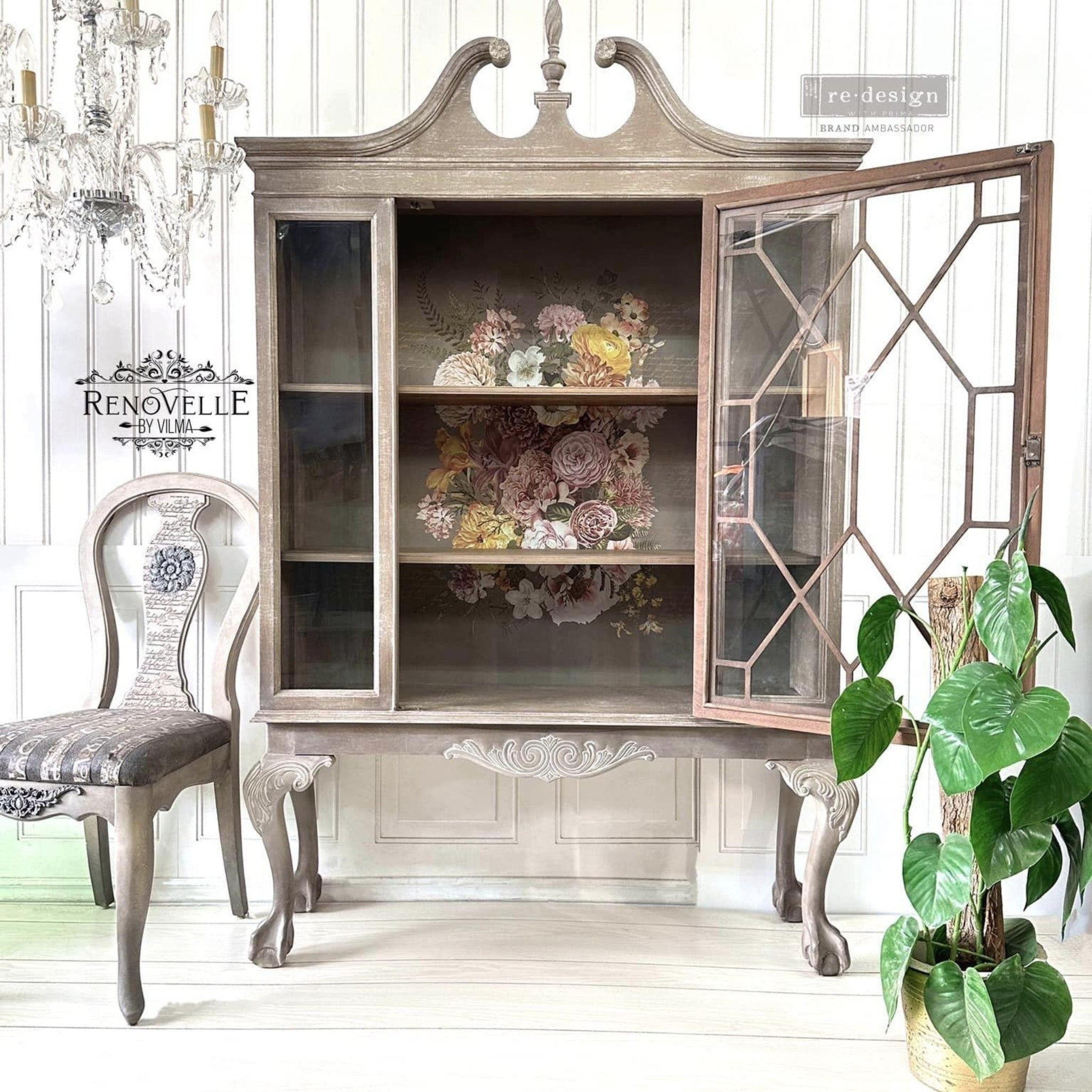 A vintage hutch with a big glass door refurbished by Renovelle by Vilma is a natural wood with white-wash color and features ReDesign with Prima's Kacha Woodland Floral transfer inside on the backboard.