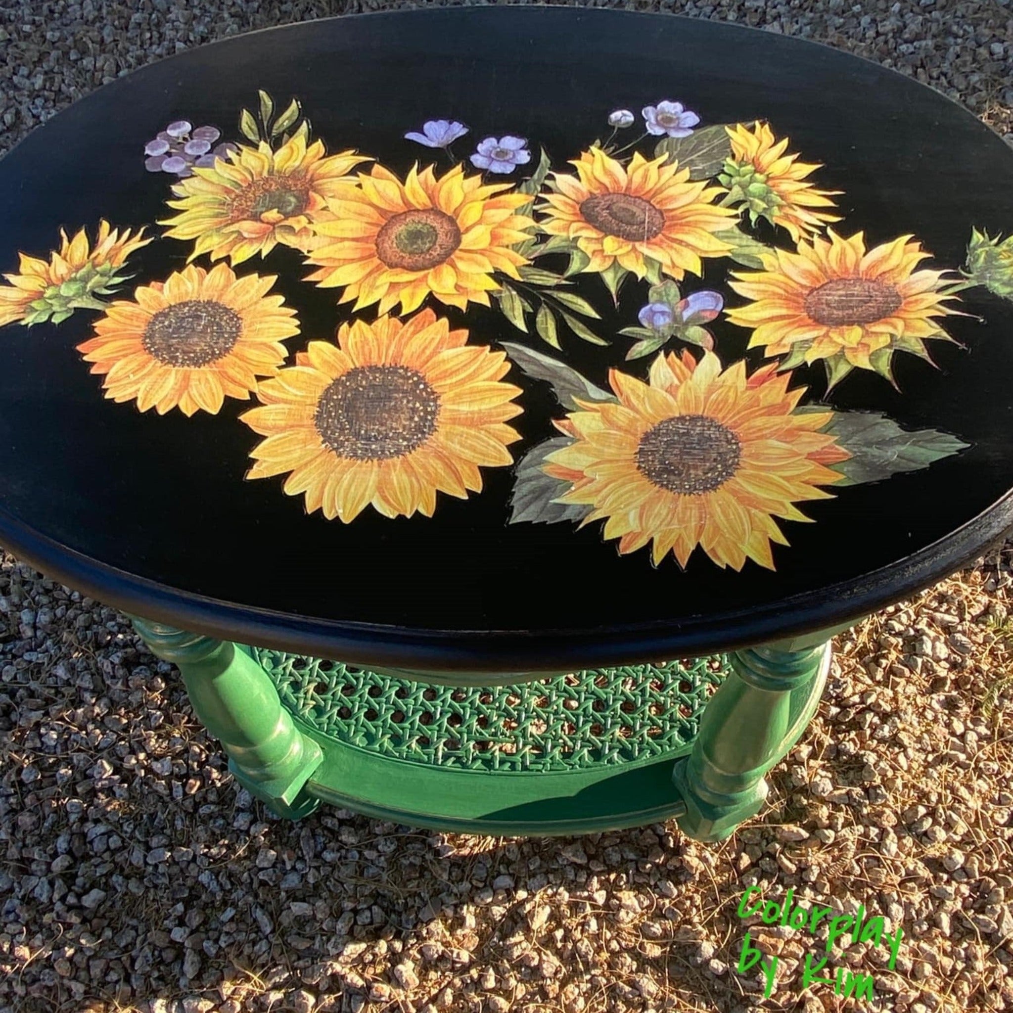 A vintage oval end table refurbished by Colorplay by Kim is painted green with a black top and features ReDesign with Prima's Sunflower Fields transfer on the table top.