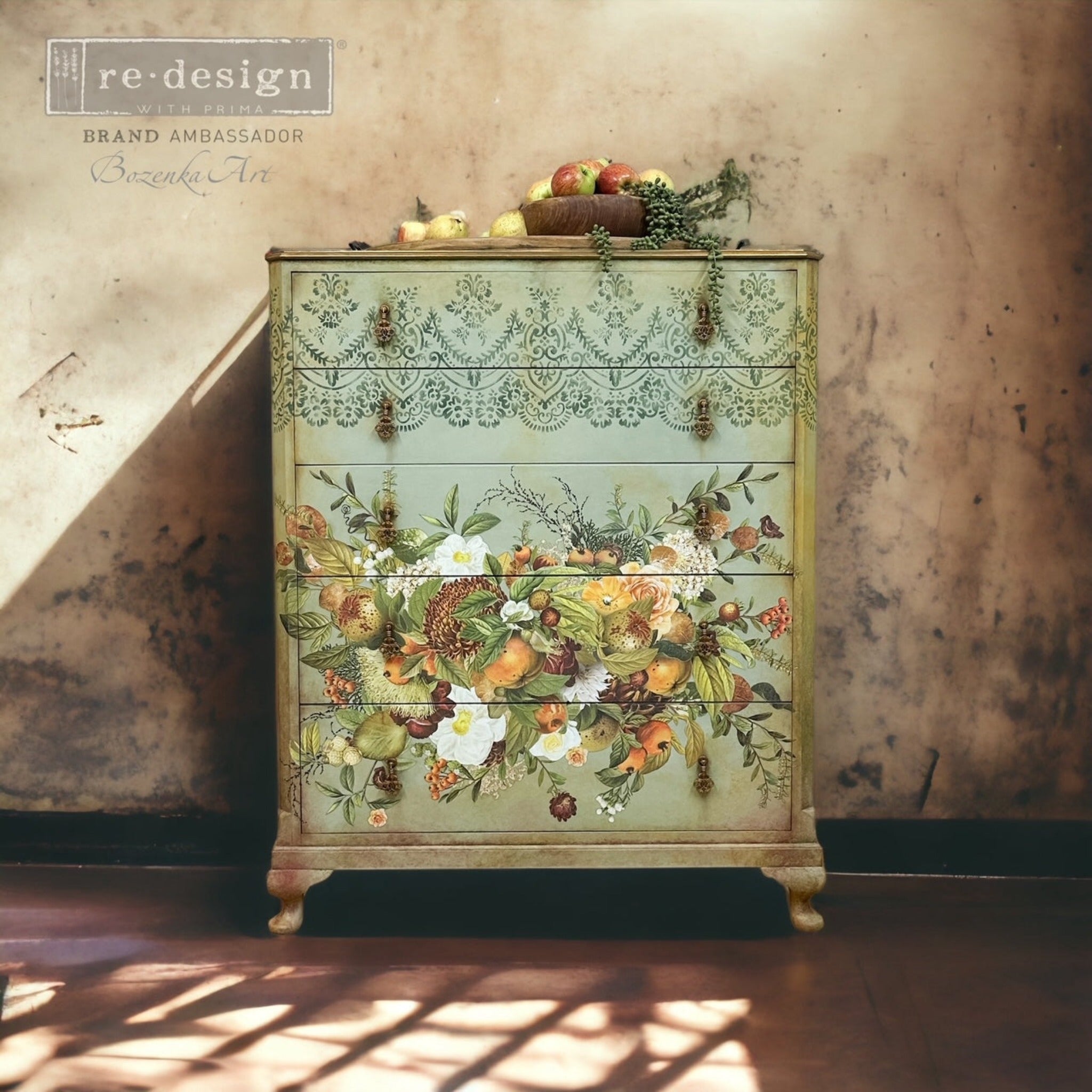A vintage 5-drawer chest dresser refurbished by Bozenka Art is painted a blend of sea foam green, Spring green, and light brown and features ReDesign with Prima's Harvest Hues transfer on its bottom 3 drawers.