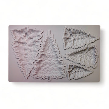 A beige silicone mold of 5 varying size pine Christmas trees is against a white background.