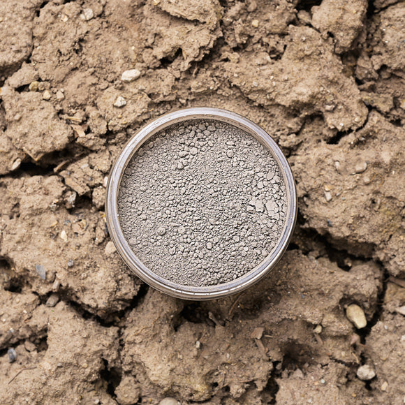 Brown Dixie Dirt in a container on a dry, cracked soil background