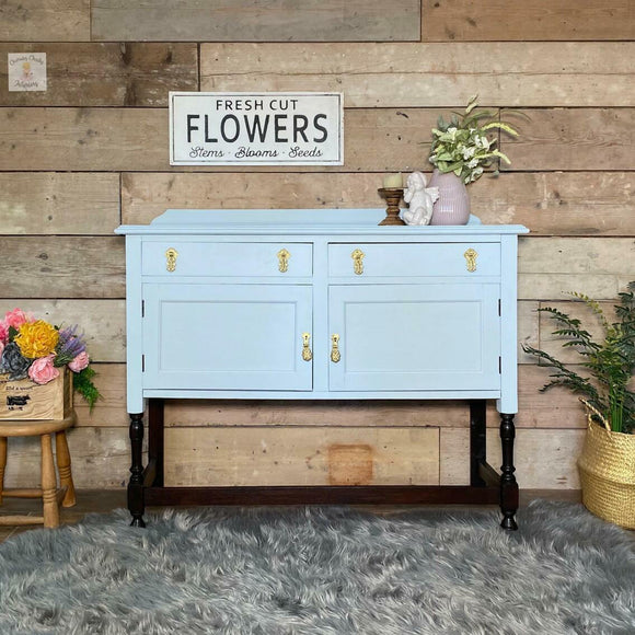 A vintage buffet table refurbished by Cherubs Chalks Interiors features Dixie Belle's Bay Breeze Silk All-In-One Mineral Paint with gold accents and dark cherry wood legs.