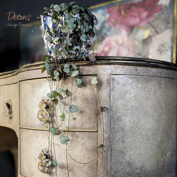 A close-up view of a vintage desk refurbished by Decoris Vintage Designs is painted light beige and features Dixie Belle Paint's Van Dyke Brown Glaze as a sponged on accent.