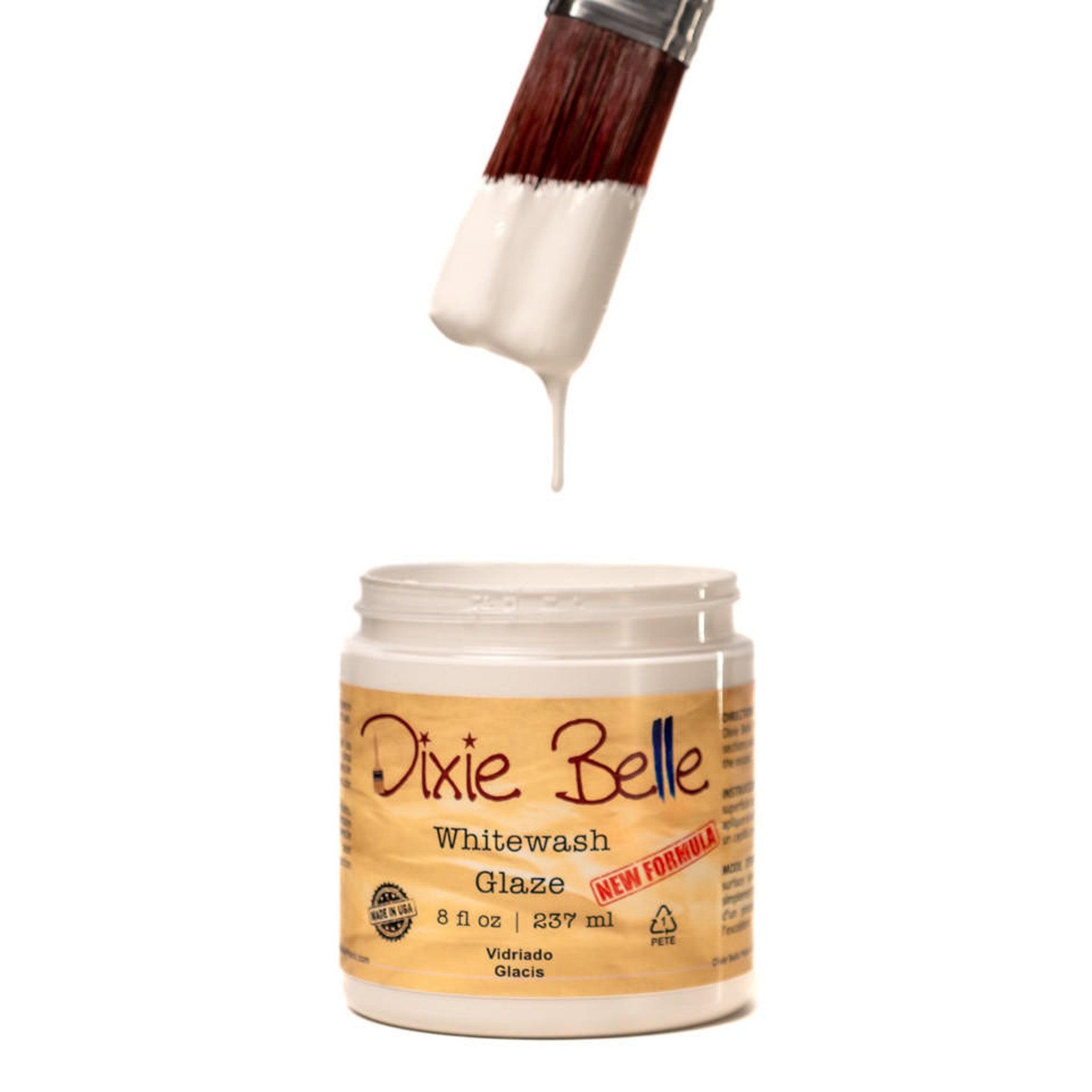 An open container of an 8oz/237ml Dixie Belle Whitewash Glaze with a dripping paintbrush above it is against a white background.
