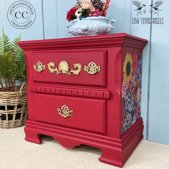 A vintage 2-drawer nightstand refurbished by Low Flying Angels features Dixie Belle's Fiery Sky Silk All-In-One Mineral Paint with gold and floral accents.