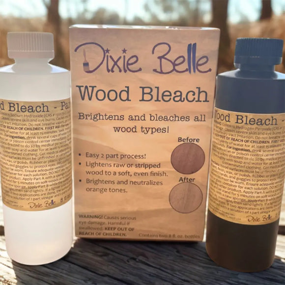 Dixie Belle Wood Bleach Kit featuring two 8 oz. bottles labeled Part A and Part B, shown outdoors in natural light with product packaging. The box highlights the wood bleach’s benefits for brightening, neutralizing orange tones, and lightening raw or stripped wood.