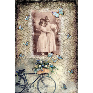 Rice paper featuring a collage of a sepia vintage portrait of two young girls in an embrace against a background of a patterned design with blue butterflies and bicycle with blue flowers in a basket.
