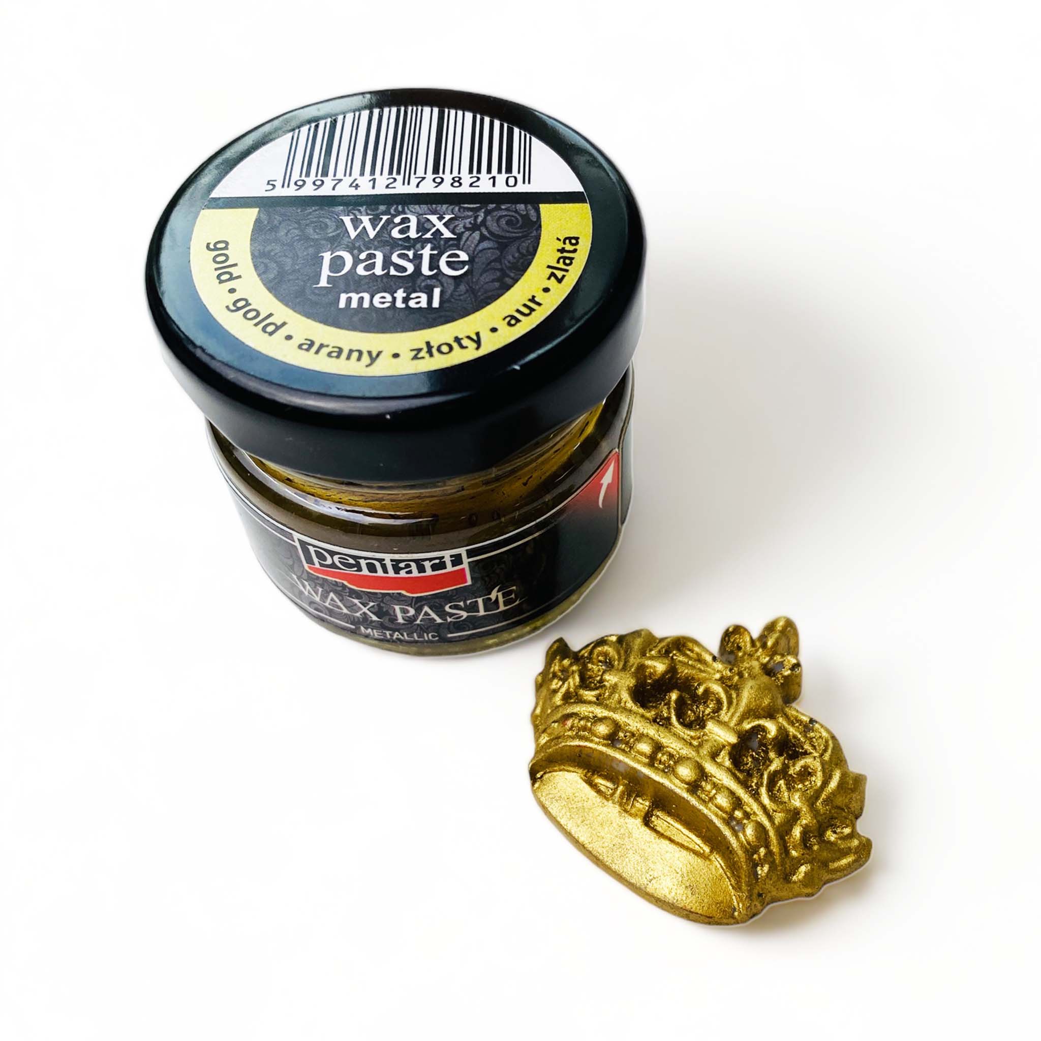 A 0.68 ounce jar of metallic gold wax paste by Pentart is against a white background. A small silicone casting of a crown is shown with the gold wax on it.