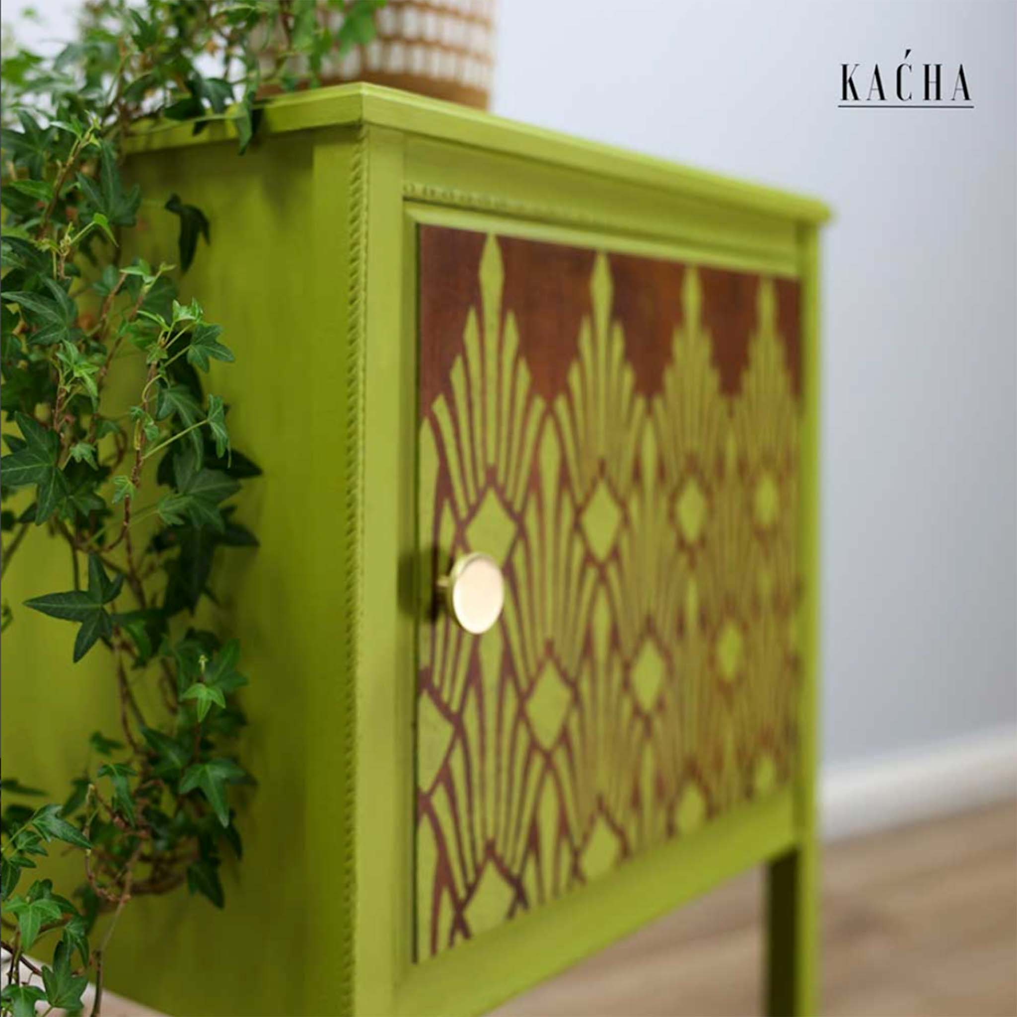 A close-up view of a small 1-door nightstand refurbished by Kacha is painted avocado green. The door is stained a dark wood color and features ReDesign with Prima's Sunlit Diamonds stencil in avocado green.