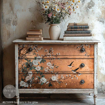 A vintage 3-drawer dresser is painted white and features ReDesign with Prima's Feathers in the Glow A1 fiber paper on the drawers.