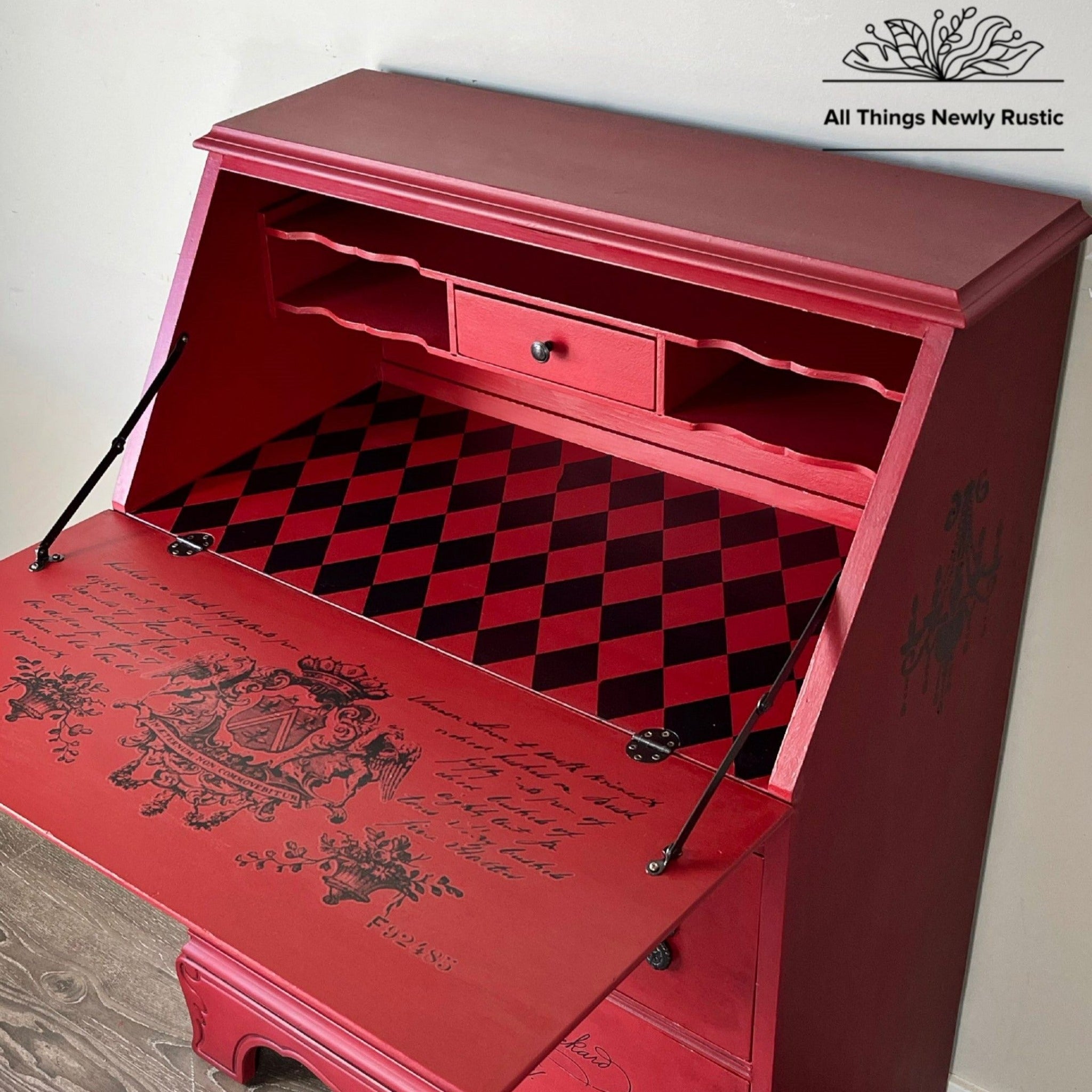 A vintage secretary desk refurbished by All Things Newly Rustic is painted red and features the Harlequin transfer inside.