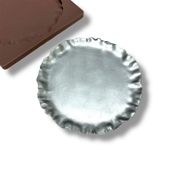 silver pie crust mold on a white background