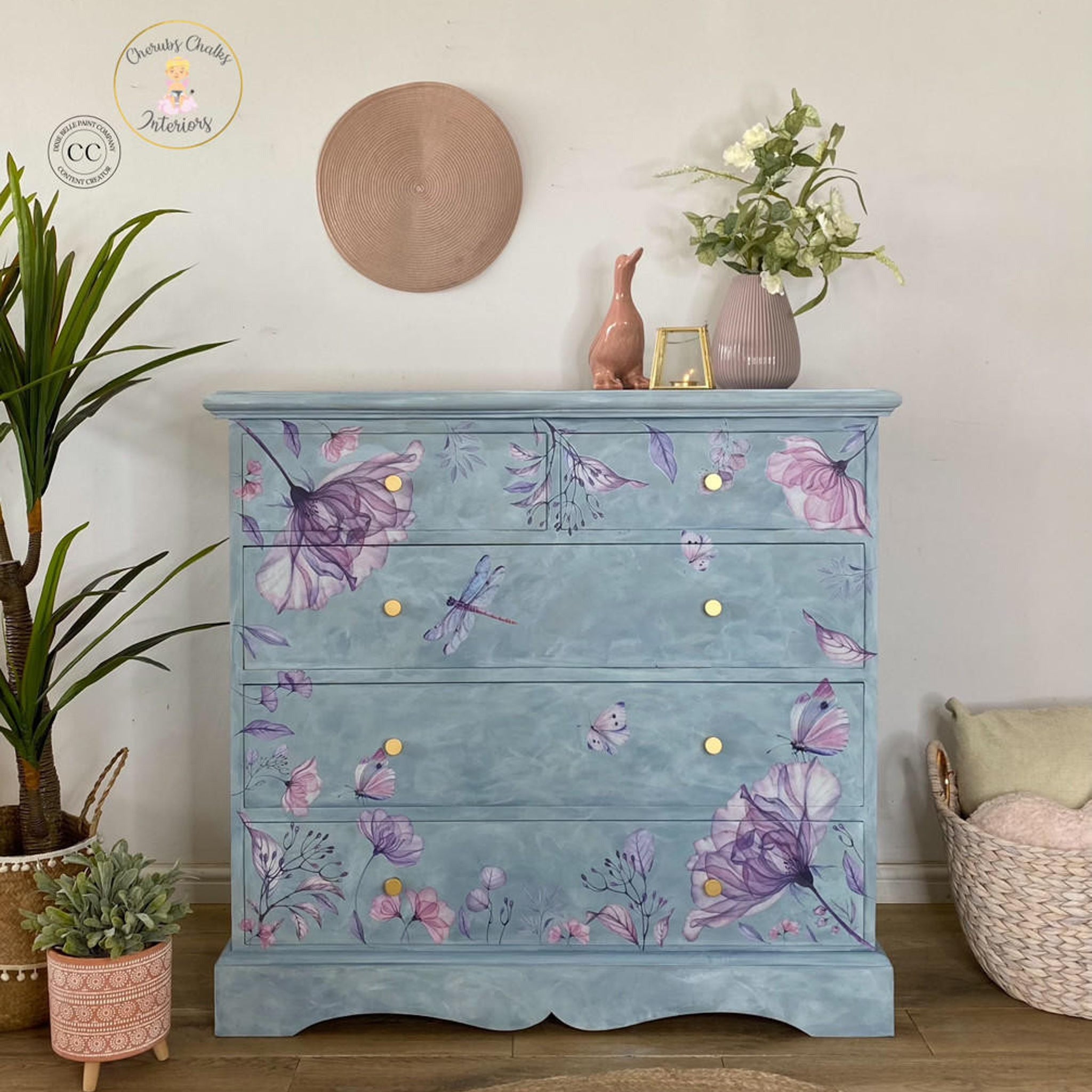 A dresser refurbished by Cherub's Chalks Interiors, a Dixie Belle Paint Company Content Creator, is painted a blended light blue and features the Translucent Garden Transfer on the front.