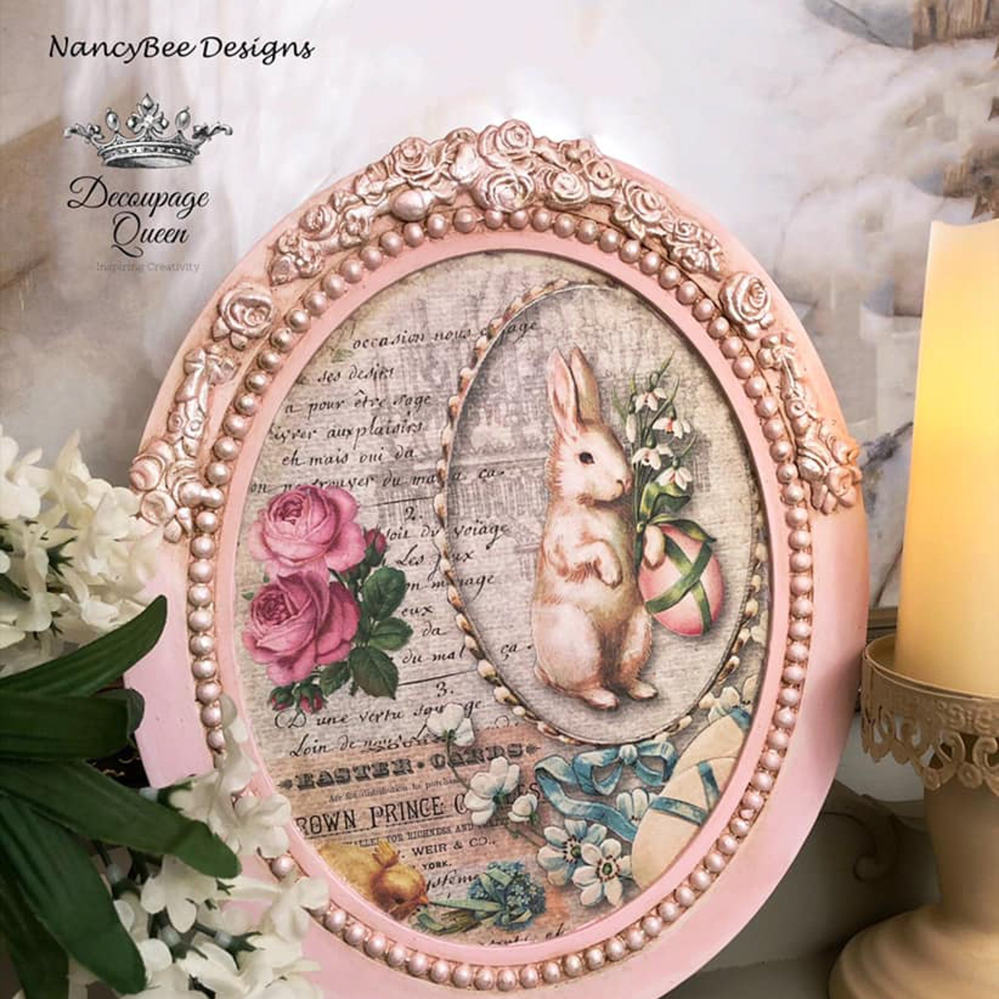 An ornate frame refurbished by Nancy Bee Designs is painted pale pink and features the Nancy's Spring Bunnies A4 rice paper. A Decoupage Queen logo is also in the top left corner.