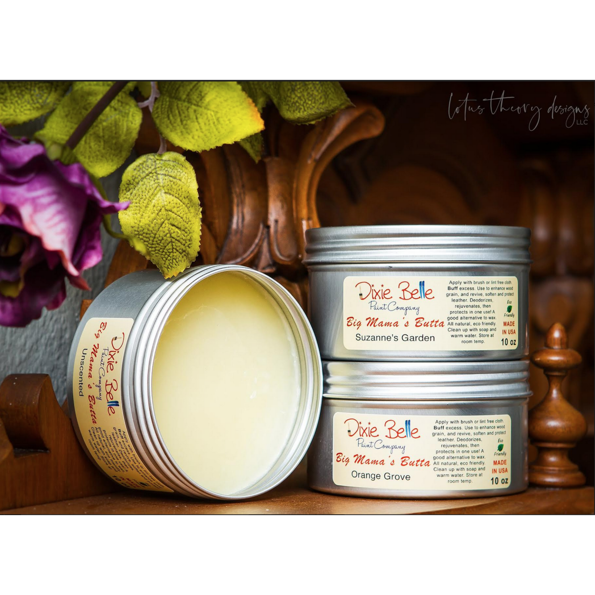 Three 10oz tins of Dixie Belle Paint's Big Mama's Butta in Unscented, Suzanne's Garden, and Orange Grove. The tin of Unscented is laying on its side with the lid off to show the product inside.