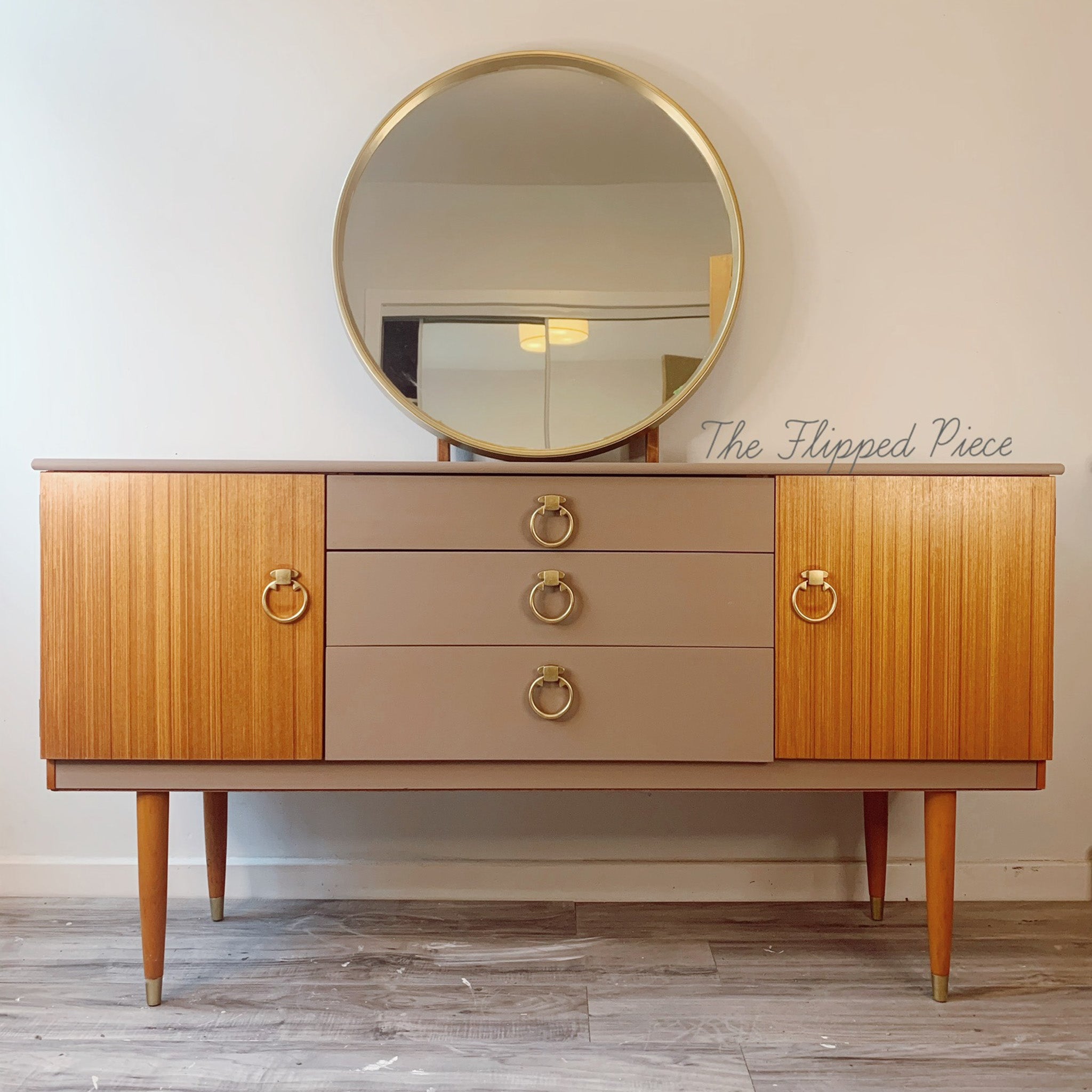 A mid-century dresser refurbished by The Flipped Piece is painted in Dixie Belle's Mud Puddle chalk mineral paint and has 2 doors and legs in natural wood.