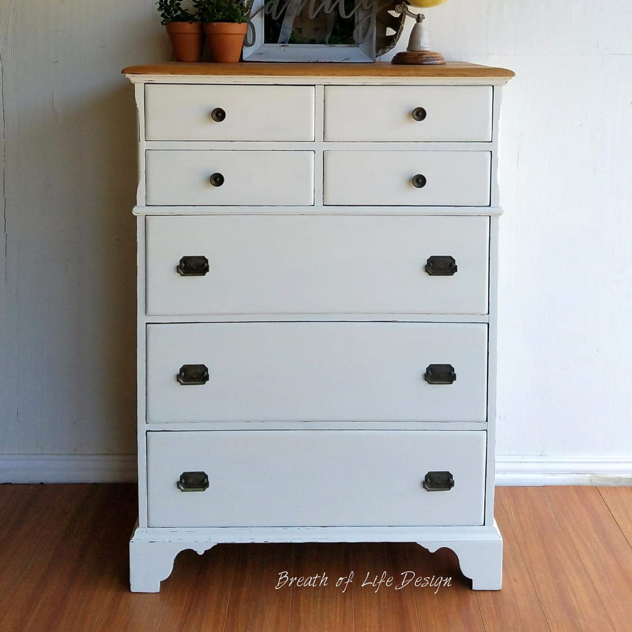 A 7-drawer vintage chest dresser refurbished by Breath of Life Design is painted in Dixie Belle's Buttercream chalk mineral paint.