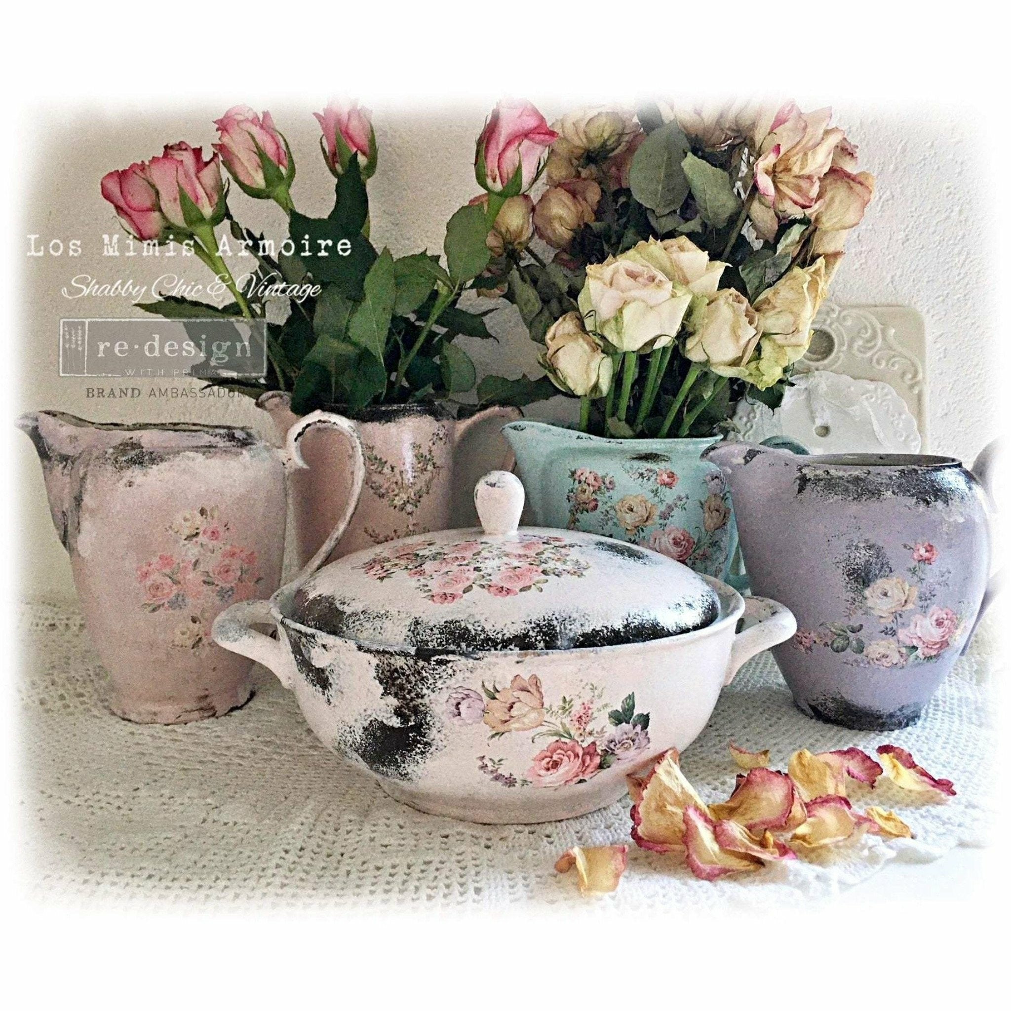 Four vintage cream pitchers and 1 vintage casserole dish with a lid are painted pastel colors and feature ReDesign with Prima's Sweet Spring knob transfers on it.