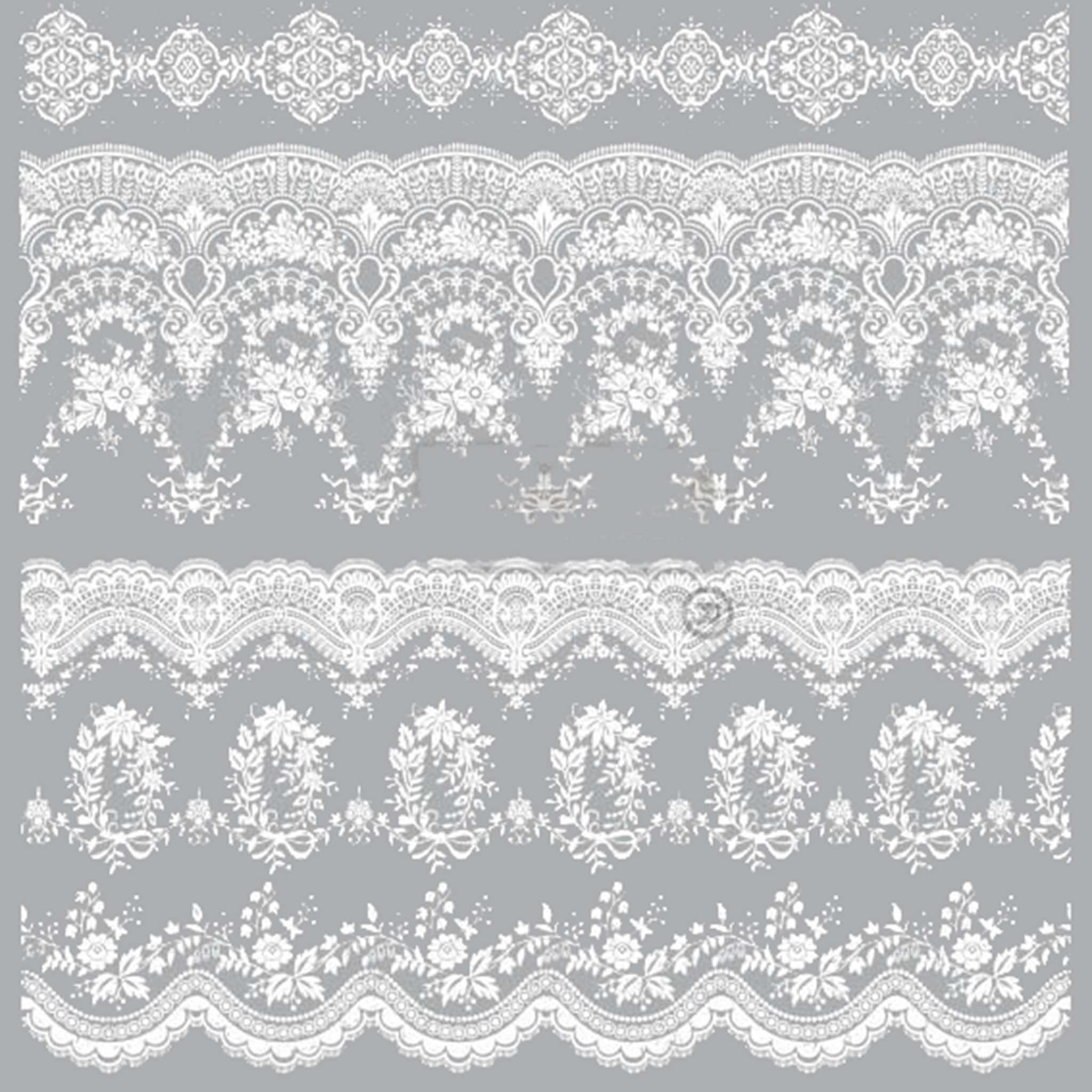 Small rub-on transfer of a white vintage lace wallpaper design on a grey background.