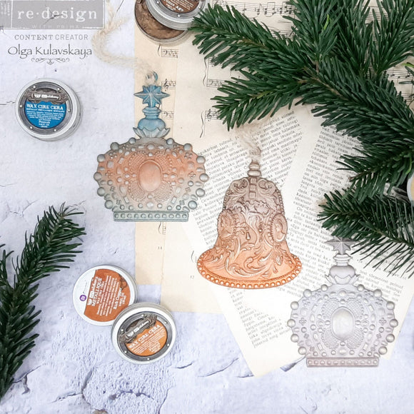 Three castings of ReDesign with Prima's Victorian Adornments are on vintage sheet music with springs of pine and containers of decor wax.
