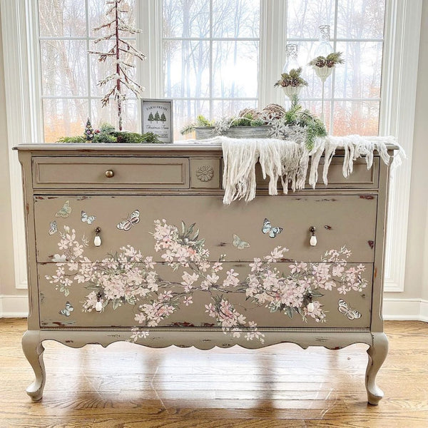 A vintage French Provencial 4-drawer dresser is painted light beige and features ReDesign with Prima's Blossom Botanica transfer on its bottom 2 large drawers.
