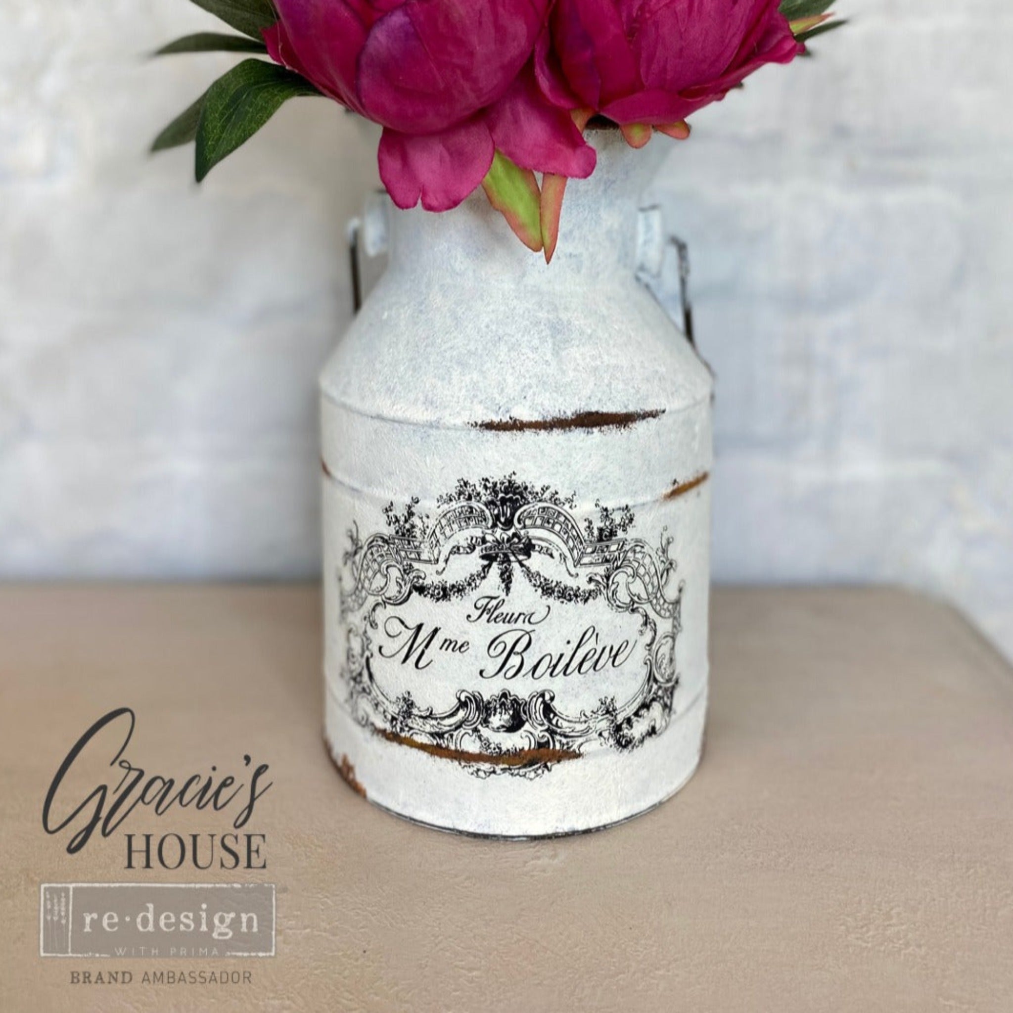 A small vintage jug refurbished by Gracie's House is painted a weathered white and features ReDesign with Prima's Classic Vintage Labels transfer on it.