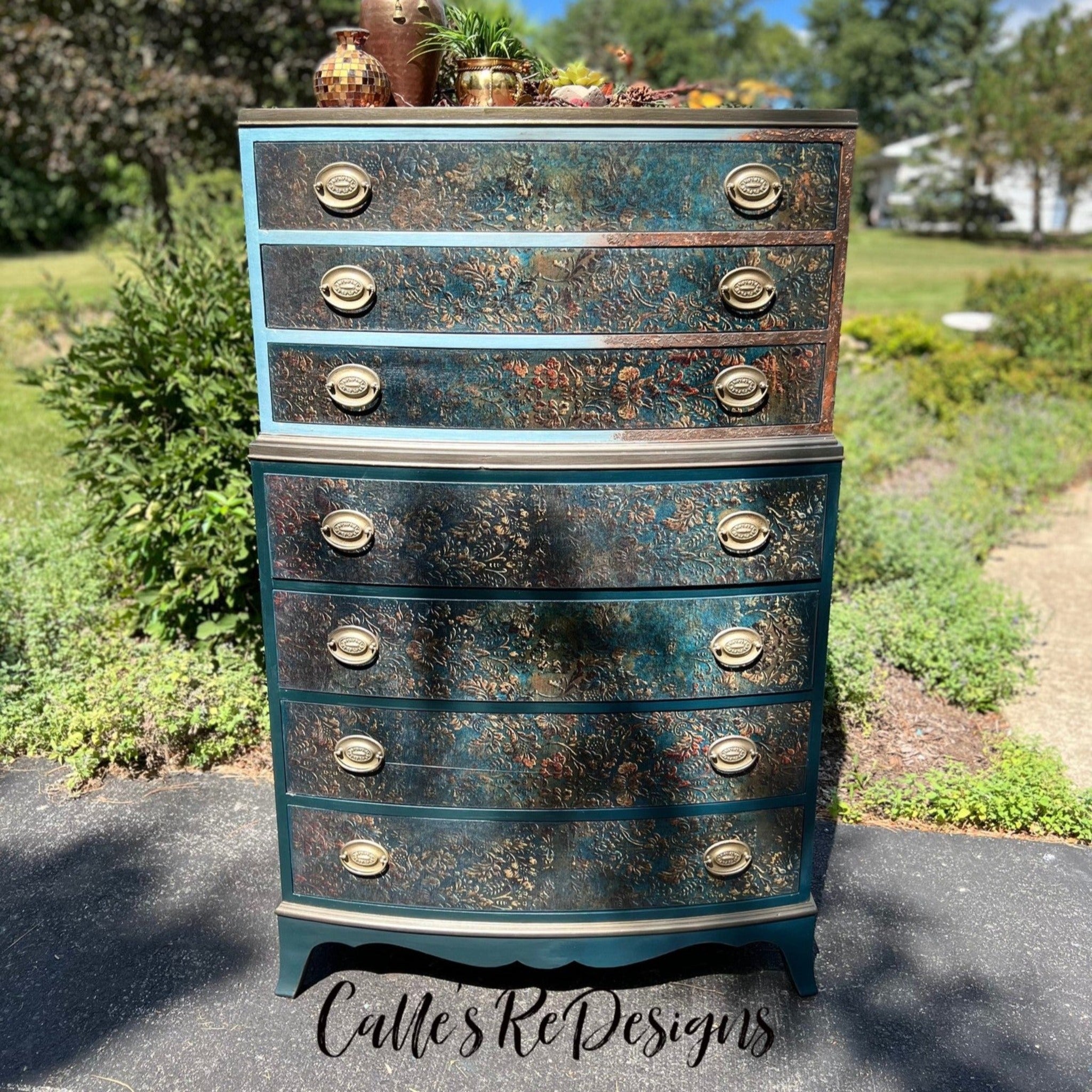A vintage 7-drawer chest dresser refurbished by Calle's ReDesigns is painted teal and features ReDesign with Prima's Aged Patina A1 fiber paper on the drawers.