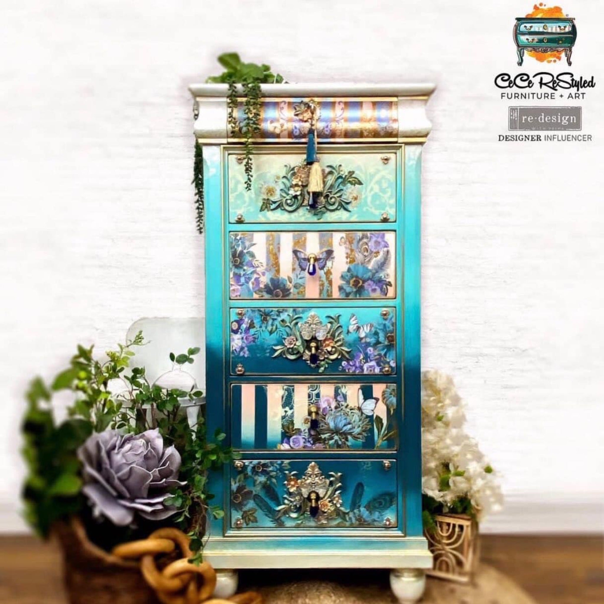 A 6-drawer lingerie chest refurbished by CeCe ReStyled is painted an ombre blend of white down to dark teal and features ReDesign with Prima's Gilded Floral small transfer on some of its drawers along with a few other floral transfers and silicone mould castings.