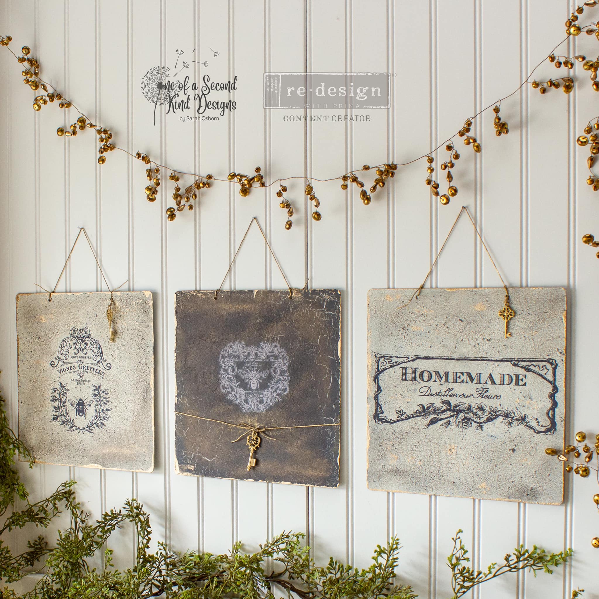 Three decorative hanging metal plates refurbished by One of a Second Kind Designs feature ReDesign with Prima's French Labels small transfer on them.