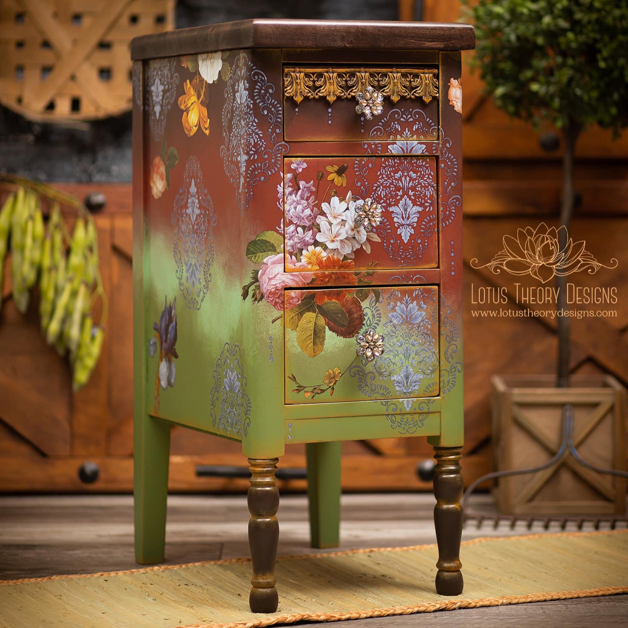 A small 3-drawer vintage night stand refurbished by Lotus Theory Designs is painted an ombre of brown down to Spring green and features ReDesign with Prima's Blossomed Beauties small transfer on it.