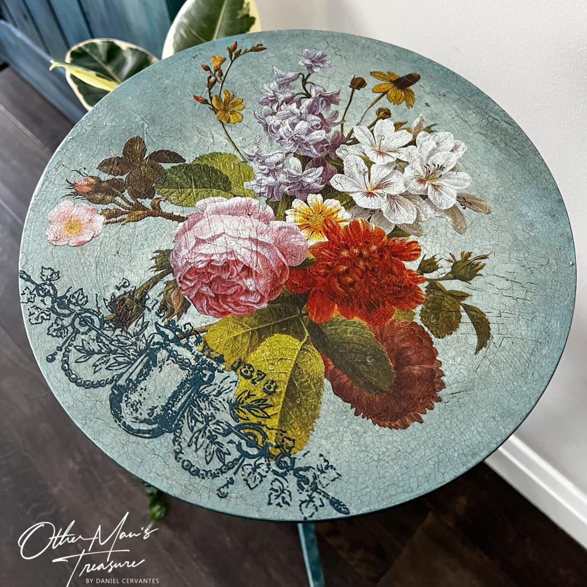 An arial view of a vintage plant stand refurbished by Other Man's Treasure is painted a crackle light blue and features ReDesign with Prima's Blossomed Beauties small transfer on it.