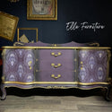 A vintage buffet table refurbished by Elle Furniture is painted a soft purple with gold accents and features ReDesign with Prima's Kacha Dana Damask on its 2 doors that are on the front left and right.
