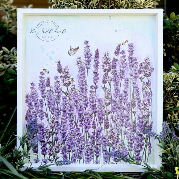 A large white painted wood framed canvas refurbished by New Old Finds features ReDesign with Prima's Champs de Lavende transfer on it.