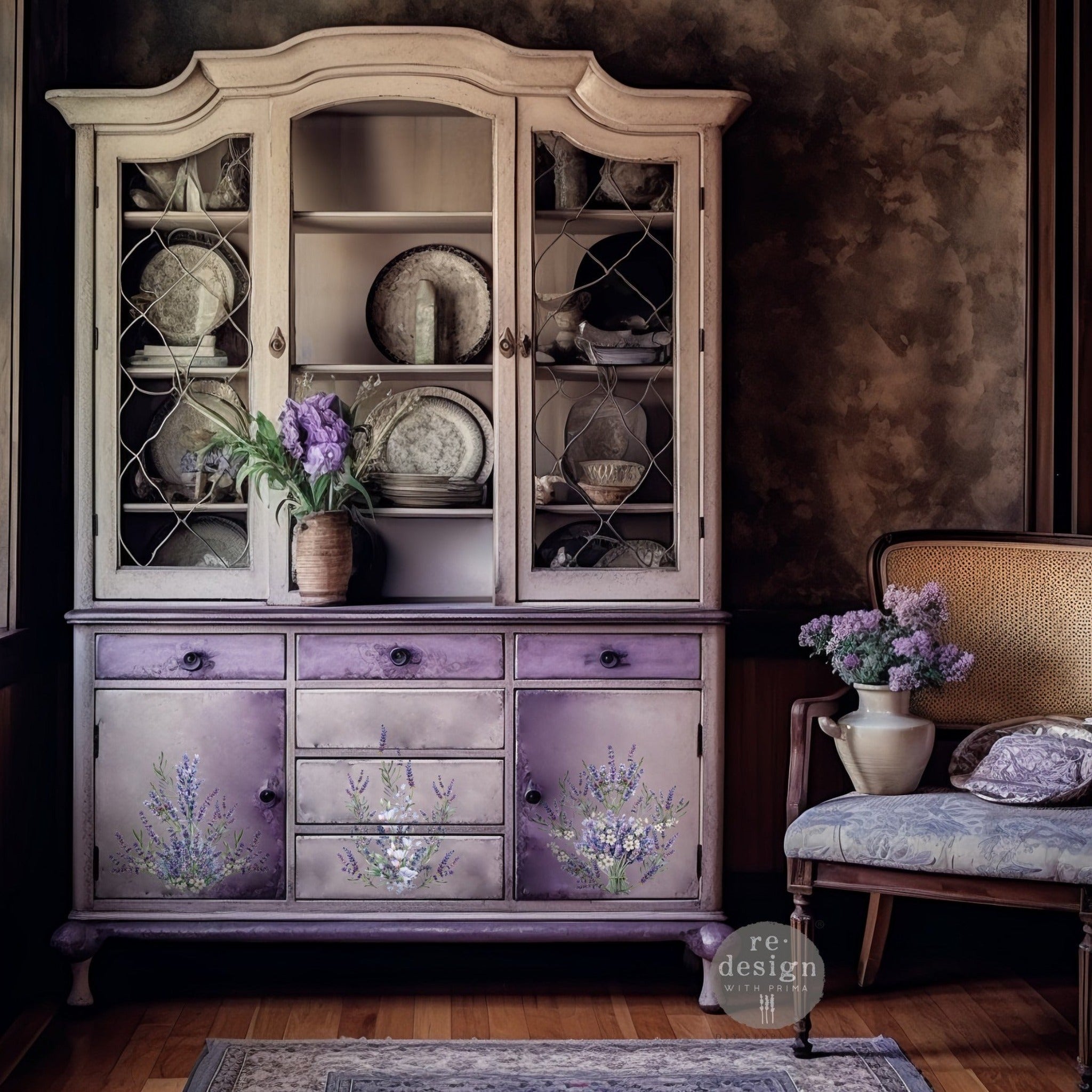 A vintage hutch is painted light beige on the top half and a blend of light and dark lavender on the bottom. ReDesign with Prima's Lavender Bunch small transfer is featured on the bottom doors and drawers.