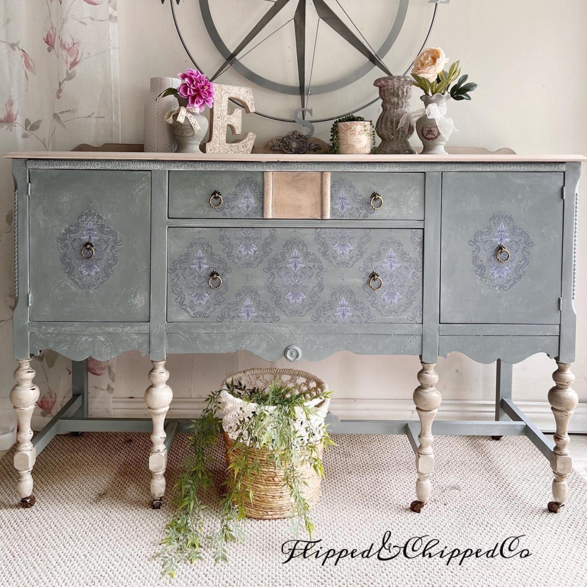 A vintage console table refurbished by Flipped & Chipped is painted concrete gray and features ReDesign with Prima's Kacha Dana Damask on its doors and drawers.