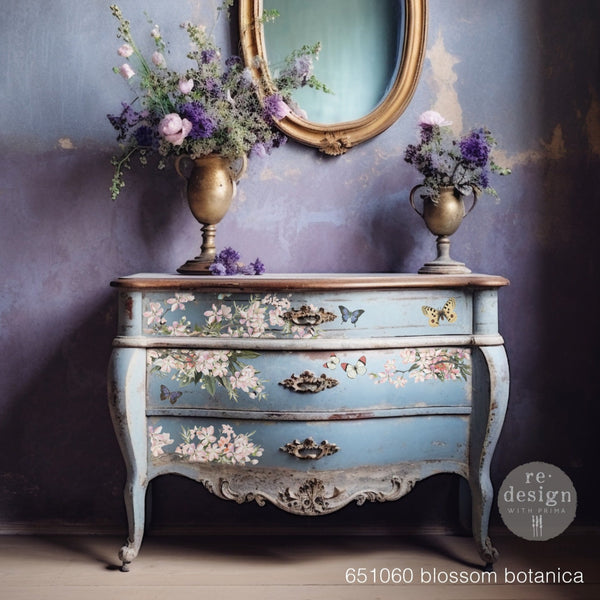 A vintage 3-drawer dresser is painted a weathered light blue and features ReDesign with Prima's Blossom Botanica on its drawers.