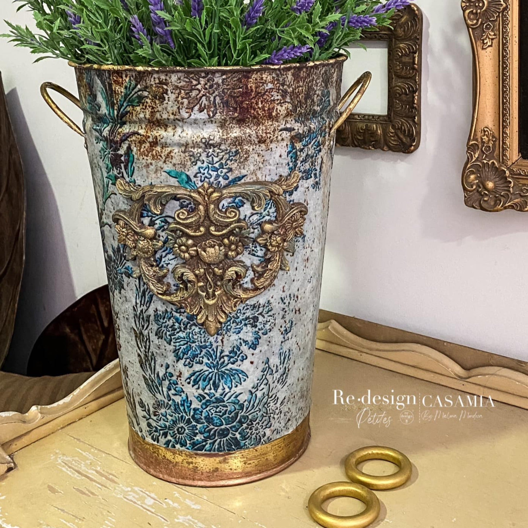 A metal can turned into a vase refurbished by Casamia by Malena Mendoza features ReDesign with Prima's Rustic Patina tissue paper along with a gold painted silicone mould casting and antiqued gold accents.