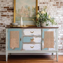 A vintage small buffet table is painted light blue and white with tan distressing and features ReDesign with Prima's Cane Rattan tissue paper on its 2 door inlays.
