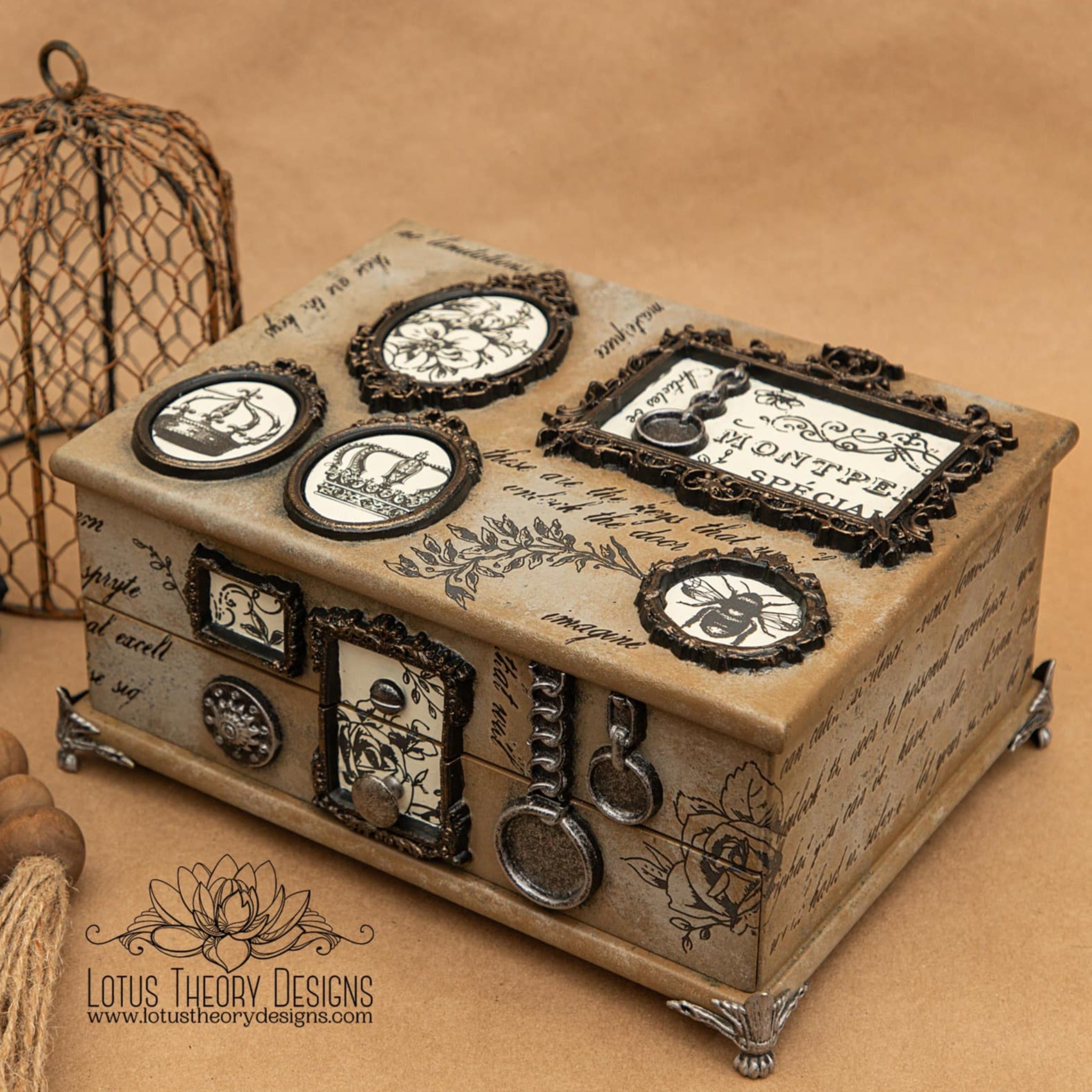 A small wood jewelry box refurbished by Lotus Theory Designs is painted a blend of light and medium brown. Silicone mould castings of small ornate picture frames on the box feature ReDesign with Prima's French Labels small transfer inside them.