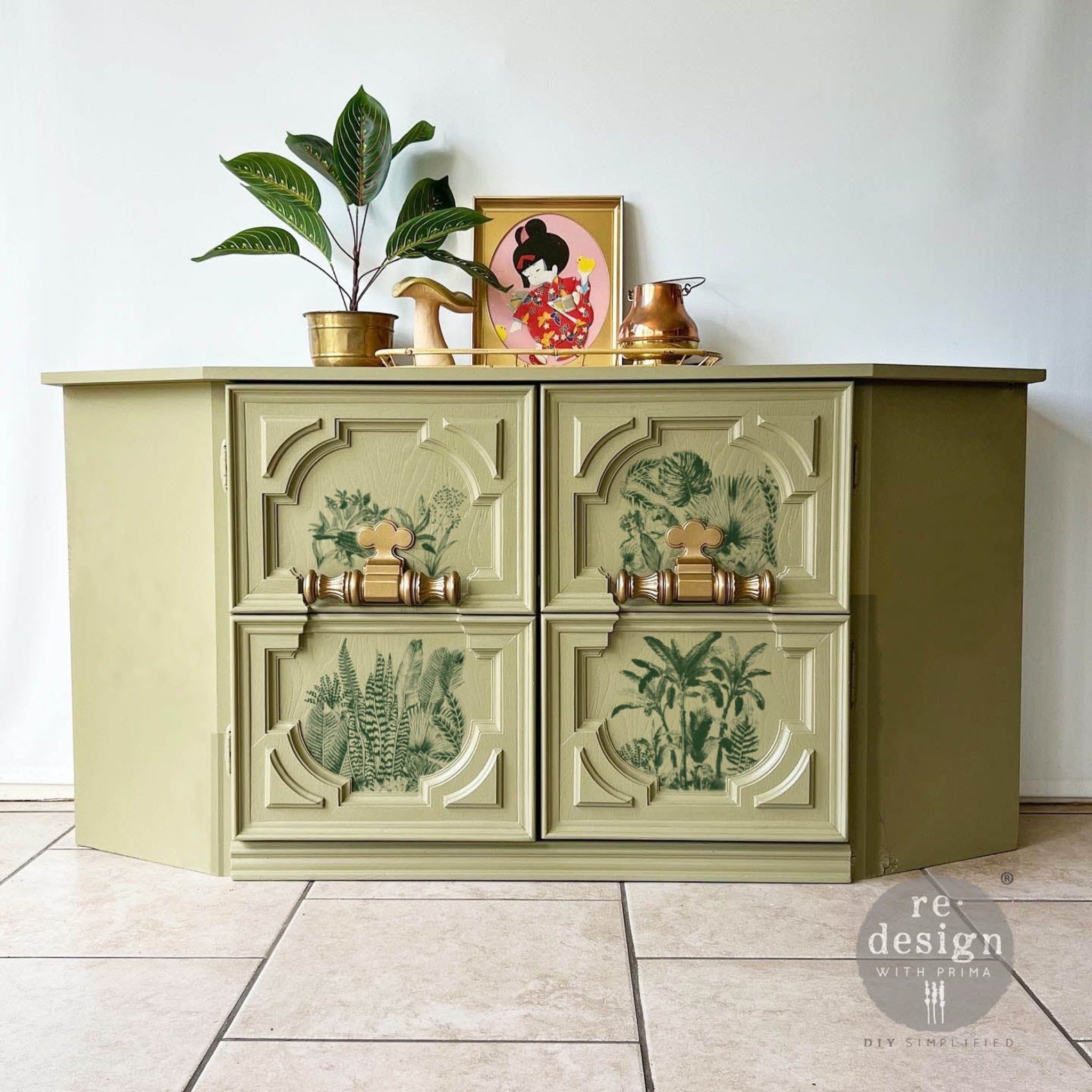 A TV console table is painted light sage green and features ReDesign with Prima's Magic Jungle small transfer on its 2 doors.
