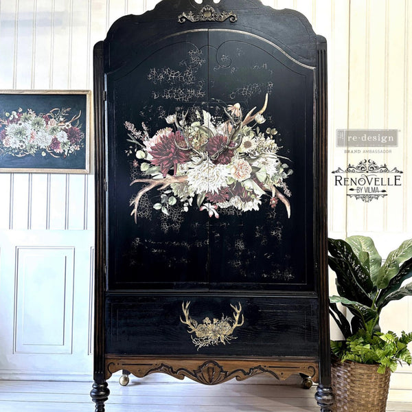 A vintage armoire refurbished by Renovelle by Vilma is painted black and features ReDesign with Prima's Rustic Charm transfer on its 2 large doors.