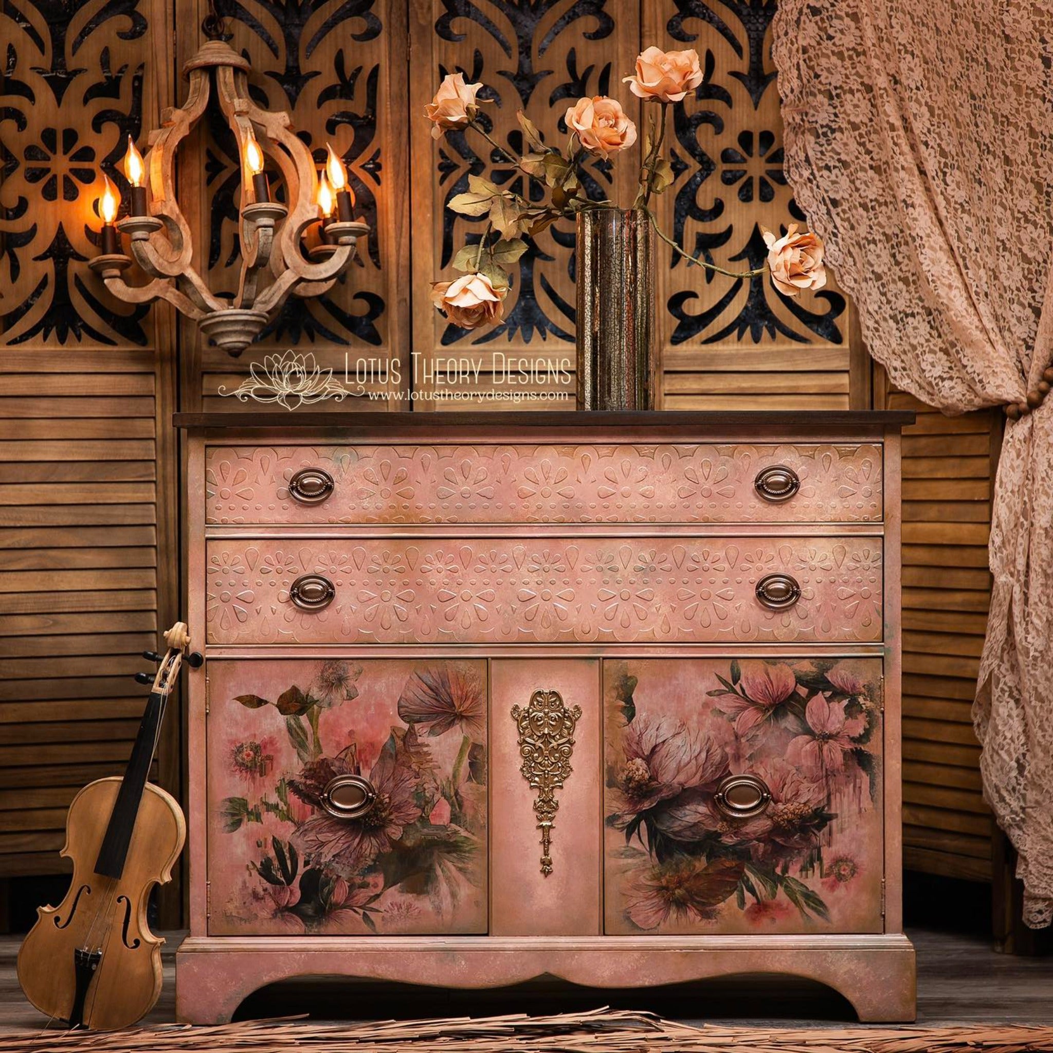 A dresser refurbished by Lotus Theory Designs is painted mauve pink and features ReDesign with Prima's Golden Emblem silicone mould on a panel that is between its 2 bottom doors that are under 2 long top drawers.