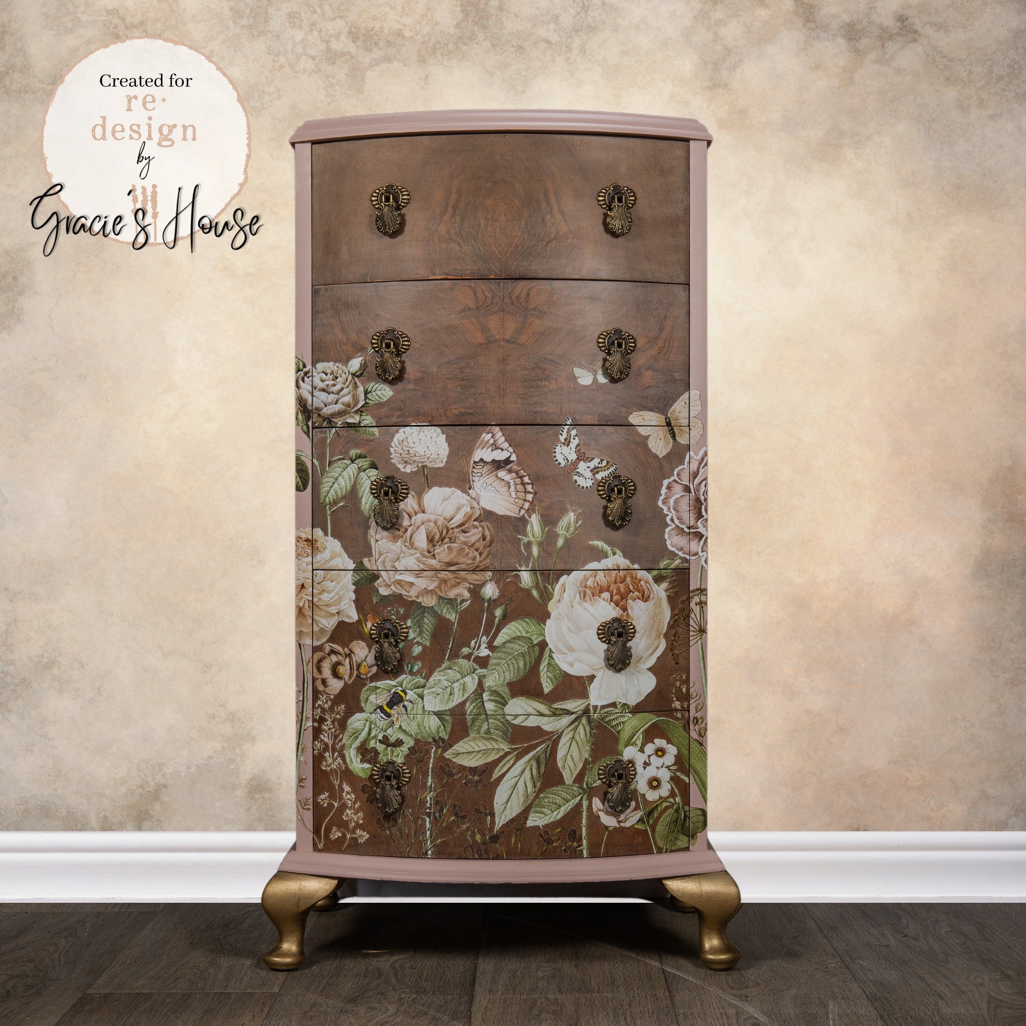 A vintage 5-drawer chest dresser refurbished by Gracie's House is painted mauve with bronze accents and features ReDesign with Prima's All the Flowers transfer on natural dark wood drawers.