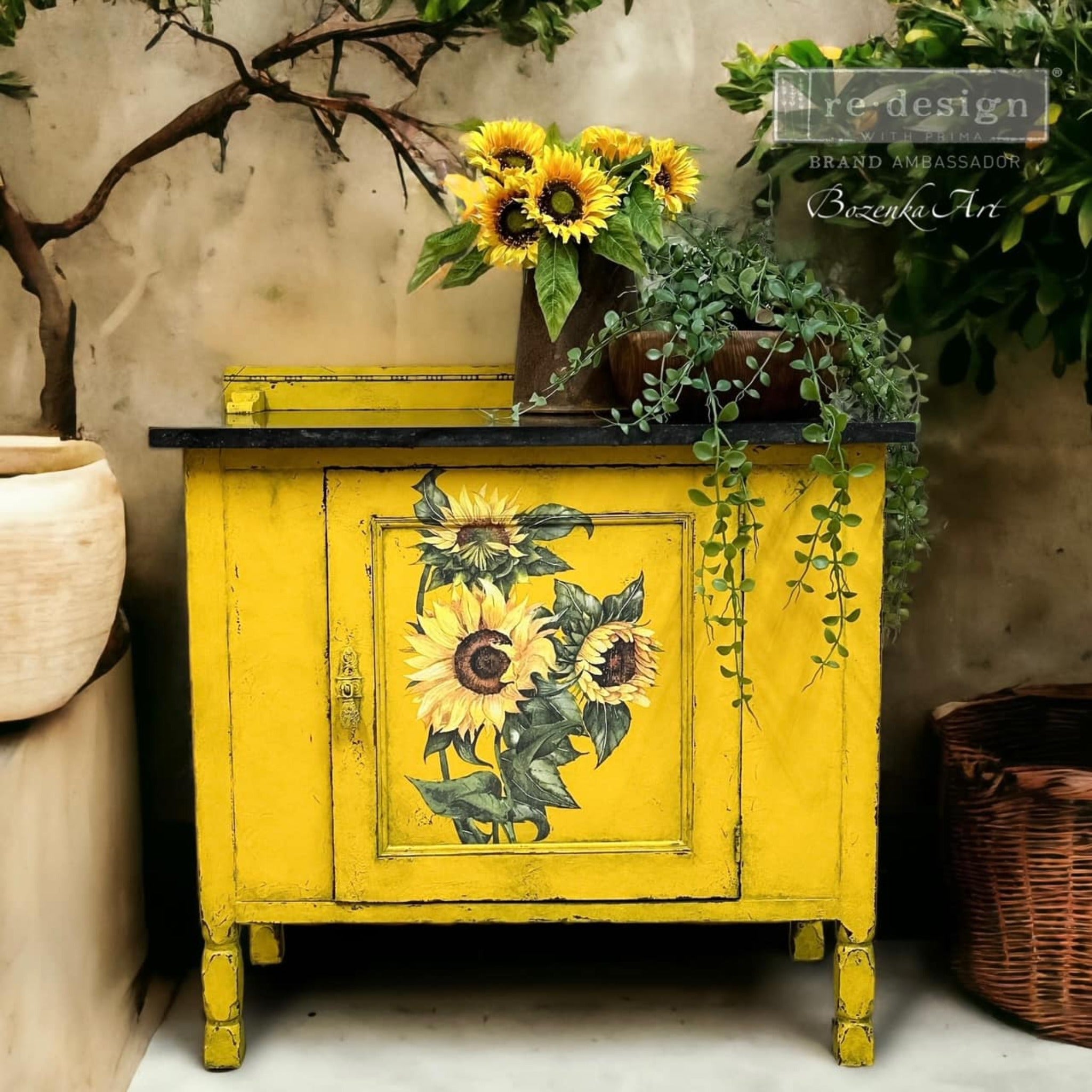 A vintage storage table refurbishd by Bozenka Art is painted bright sunflower yellow and features ReDesign with Prima's Sunflower transfer on its door.