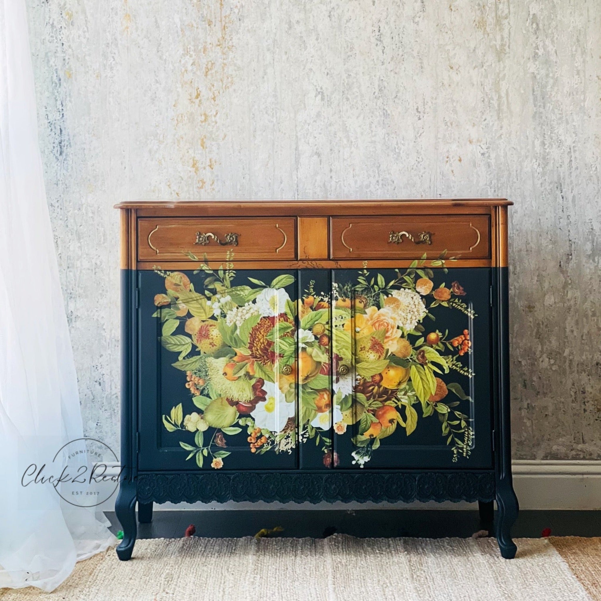 A small buffet table refurbished by Click 2 Restore is painted navy blue with natural wood  for the top and 2 top drawers and features ReDesign with Prima's Harvest Hues transfer in the center of the bottom 2 doors.
