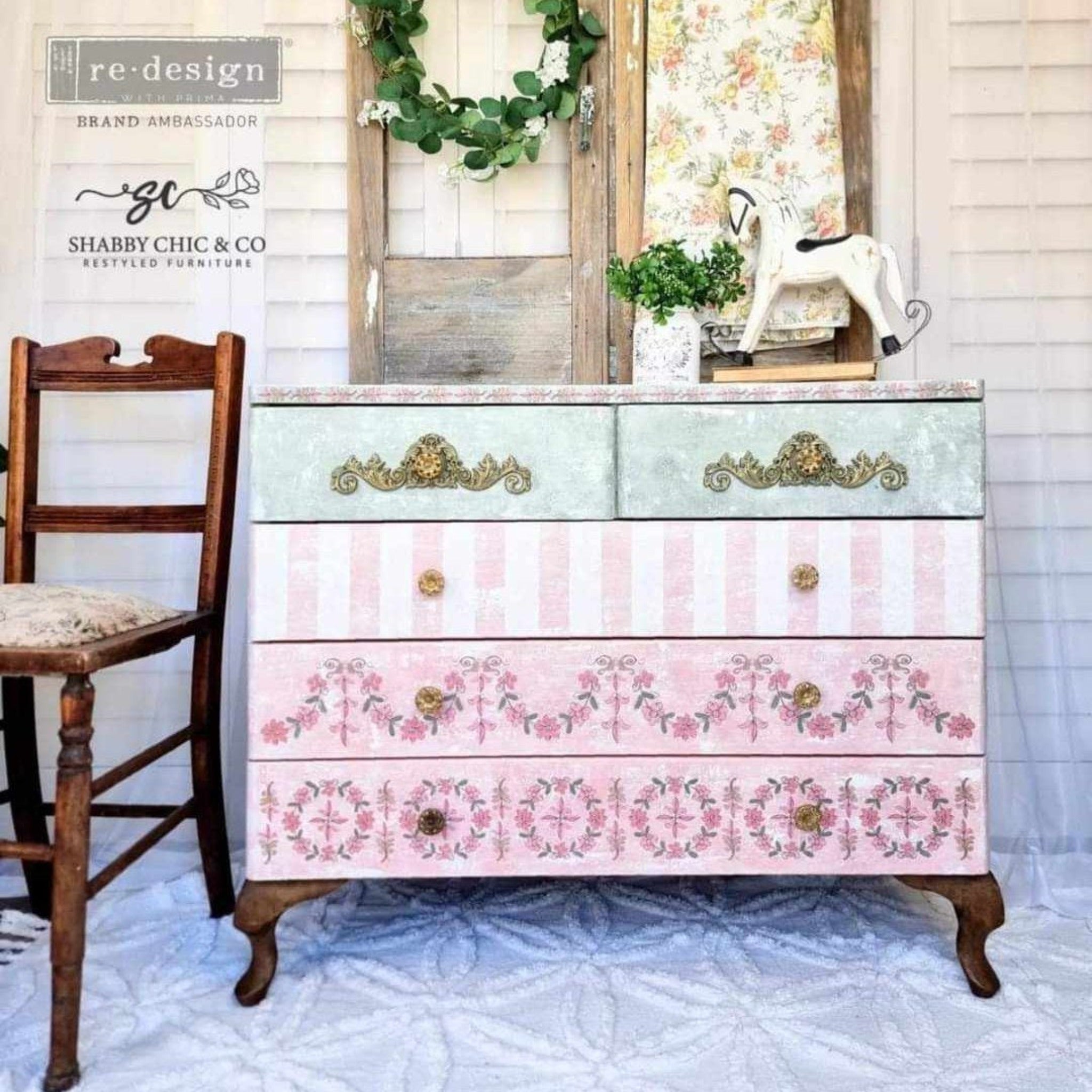 A vintage 5 drawer dresser refurbished by Shabby Chic & Co. features different pastel designs on the drawers. The top 2 drawers feature gold colored ReDesign with Prima's Kacha Lavish Swirls silicone mould castings around the drawer pulls.