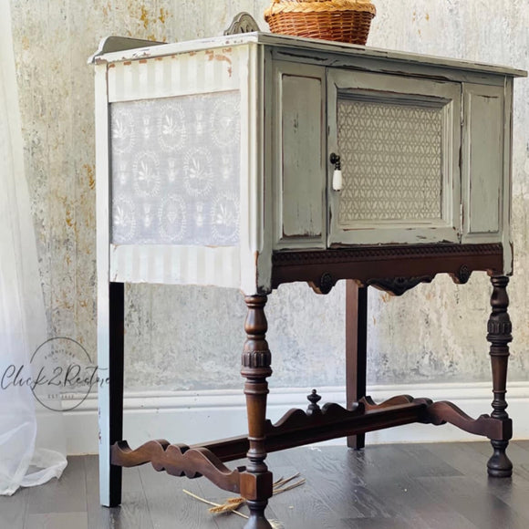 A vintage console table with storage refurbished by Click 2 Restore is painted antique white with brown legs and features ReDesign with Prima's Delicate Charm tissue paper on the side.