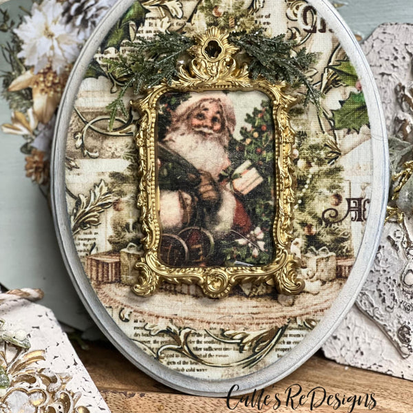 An oval wood craft created by Calle's ReDesigns features the Santa portrait and vintage sheet music designs from ReDesign with Prima's Holly Jolly Hideaway 3 pack tissue papers